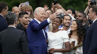 Joe Biden knipst Selfies mit Teilnehmenden des Grillfests.