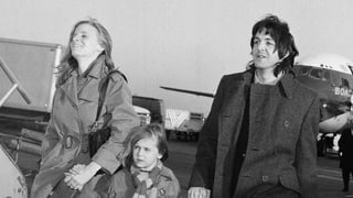 Paul McCartney mit Frau und Kind auf dem Rollfeld eines Flugplatzes.