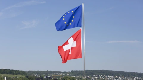 Flaggen der EU und Schweiz im Wind.