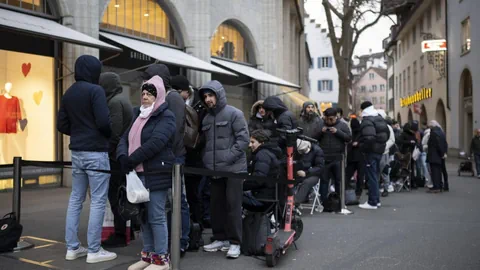 Menschen warten in einer Schlange auf die neue «MoonSwatch» vor einem Geschäft an der Zürcher Bahnhofstrasse.