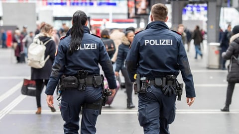 Eine Polizistin und ein Polizist patrouillieren durch den Berner Bahnhof.