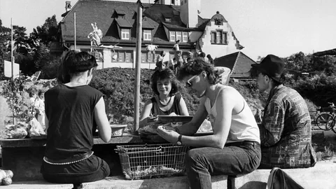 Schwarzweiss-Bild: Vier Jugendliche sitzen 1988 vor der Alten Stadtgärtnerei.