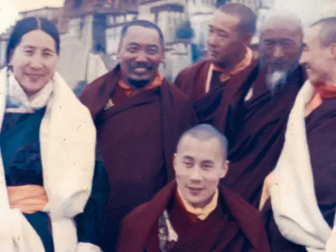 Dalai Lama als junger Mann posiert mit anderen buddhistischen Mönchen.