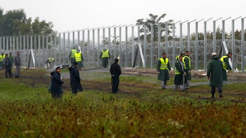 Uniformierte bewachen den Grenzzaun.