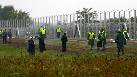 Uniformierte bewachen den Grenzzaun.