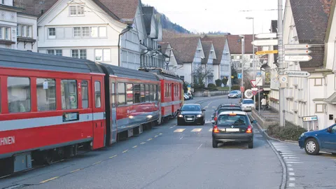 Strasse mit rotem Zug und Autos im Gegenverkehr