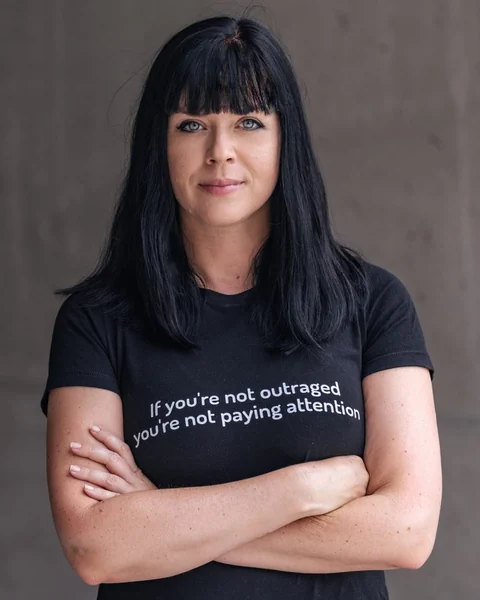 Eine Frau mit schwarzem Haar und schwarzem T-Shirt.