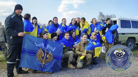 Eine Gruppe Frauen posiert für ein Foto, sie sind in ukrainische Flaggen gehüllt.