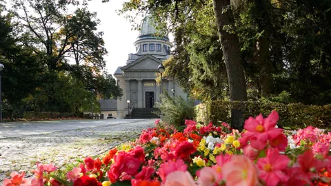 Ansicht einer Kirche mit bunten Blumen im Vordergrund.