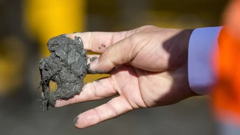 Ein bisschen Beton zwischen den Fingern einer Männerhand