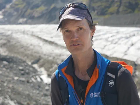 Mann vor einem Gletscher in den Bergen.