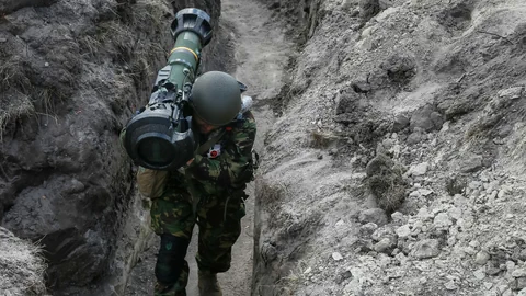 Soldat in Schützengraben mit einer Panzerabwehrrakete auf der Schulter.