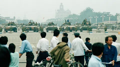 Menschen blicken auf chinesische Panzer im Juni 1989.