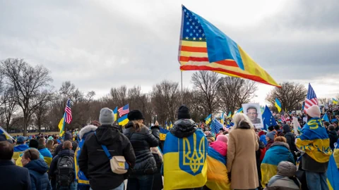 Menschenmenge mit ukrainischen Fahnen und Plakaten.