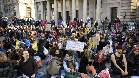 Demonstrierende sitzen vor der UBS in Lausanne und protestieren gegen den Klimagipfel in Glasgow