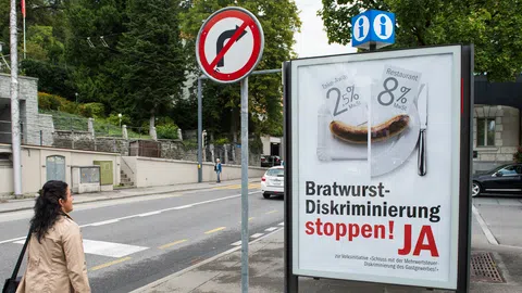 Eine Person geht an einem Plakat vorbei