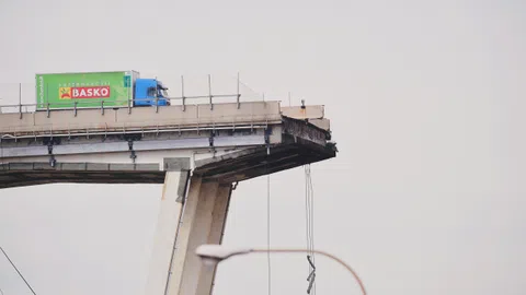 Grüner Lastwagen auf einer Brücke.