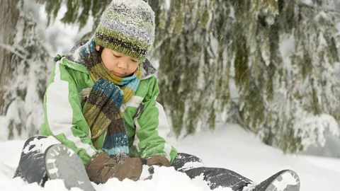 Junge sitzt im Schnee