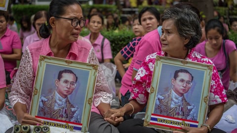 Thailänderinnen tragen gerahmte Bilder des Königs.