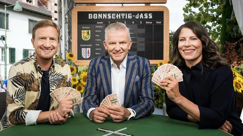 Stefan Büsser, Rainer Maria Salzgeber und Sonja Kälin mit Jasskarten an einem Tisch