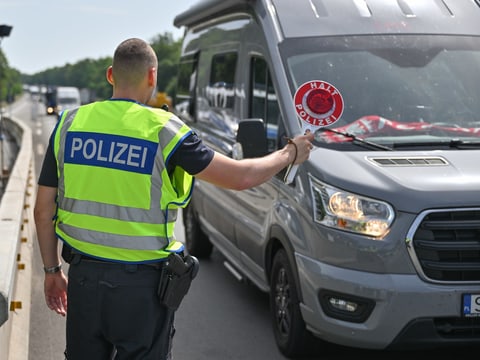 Ein deutscher Polizist steht auf der AUtobahn A12 nahe der deutsch-polnischen Grenze, stoppt ein Auto bei der Einreise.