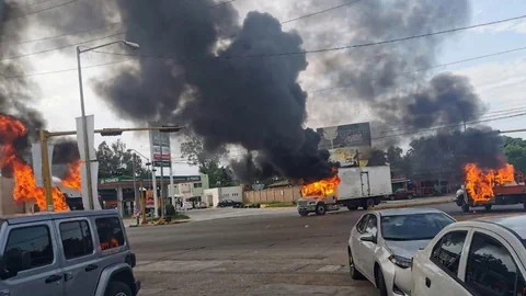 Mehrere Lastwagen in Culiacan brennen auf einer Strasse.