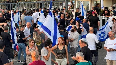 Menschenmenge mit israelischen Flaggen vor einer Militärbasis.