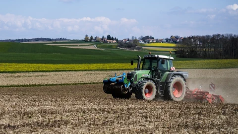 Ein Traktor fährt auf einem Acker.