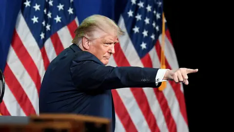 Präsident Trump zeigt mit dem Zeigefinger in die nicht sichtbare Menschenmenge.