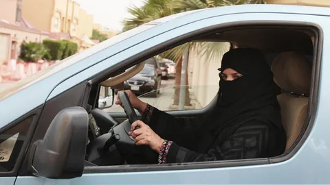 Eine verhüllte saudische Frau sitz am Steuer eines Autos.