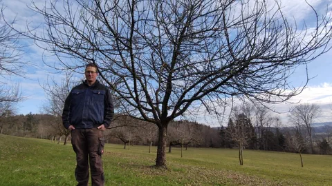 Beat Moser steht vor einem Beeriapfelbaum