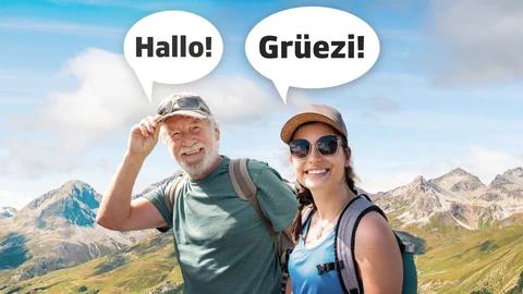 Ein Mann und eine Frau in Wanderausrüstung sagen «Hallo» resp. «Grüezi»