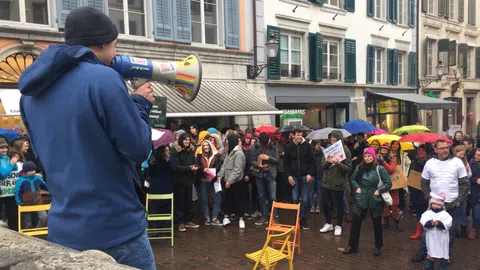 Ein Jugendlicher spricht über ein Megaphone zur Kundgebung.