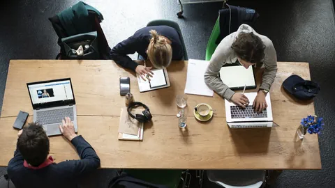 Symbolbild: Arbeitende Menschen an einem Tisch.