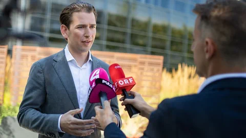 Sebastan Kurz vor zwei Mikrofonen