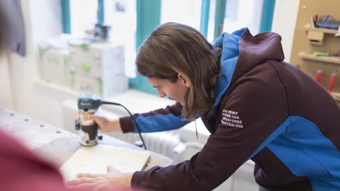 Zivildienstleistender in einer sozialen Einrichtung an einer handwerklichen Arbeit