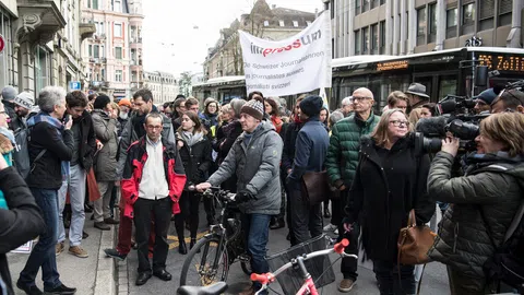 Personen mit TRansparenten auf der Strasse vor dem Redaktionsgebäude der SDA.