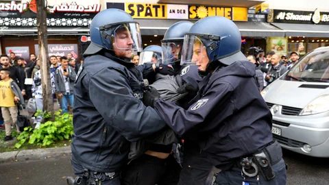 Die Polizeipersonen nehmen eine Person fest.