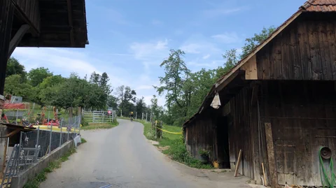 Ein schmale Strasse und Dächer, die in den Weg hineinragen.