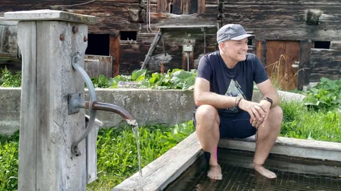 Reporter Marcel Hähni sitzt auf einem Brunnen.