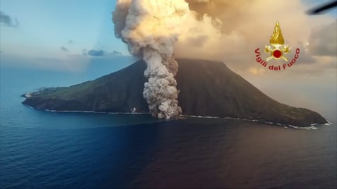 Vulkan auf einer Insel speit Rauch und Asche ins Meer.