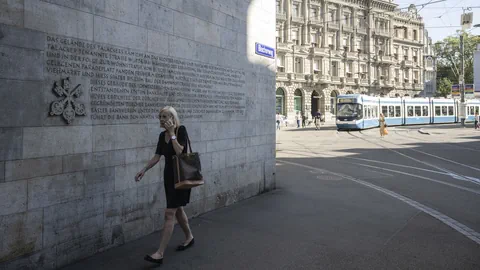 Menschen bewegen sich auf dem Paradeplatz zwischen den Banken UBS und Credit Suisse.