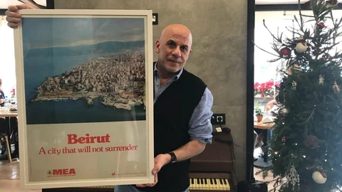 Akram Nehme hält ein Plakat mit der Aufschrift: Beirut, eine Stadt gibt nicht auf.