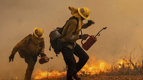 Zwei Feuerwehrmänner kämpfen in Kalifornien gegen das Feuer.