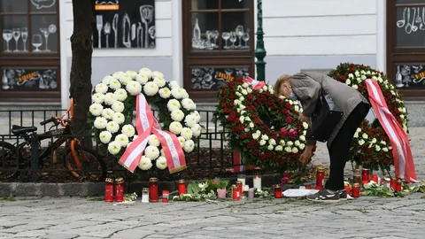 Frau legt Blumen nieder bei einem der Tatorte