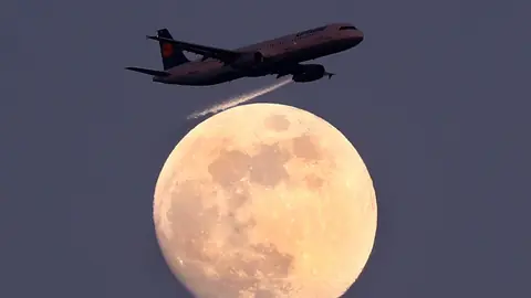 Ein Jet, im Hintergrund der Vollmond