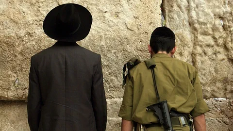 Ultraorthodoxer Jude und israelischer Soldat beten an der Klagemauer