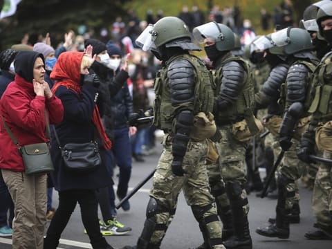 Demonstrierende vor Polizisten mit Schlagstöcken bei den Protesten in Minsk im Herbst 2020.