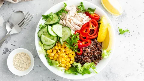 Ein Teller mit Salat, Quinoa und Poulet.