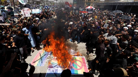 Demonstranten verbrennen Flaggen.